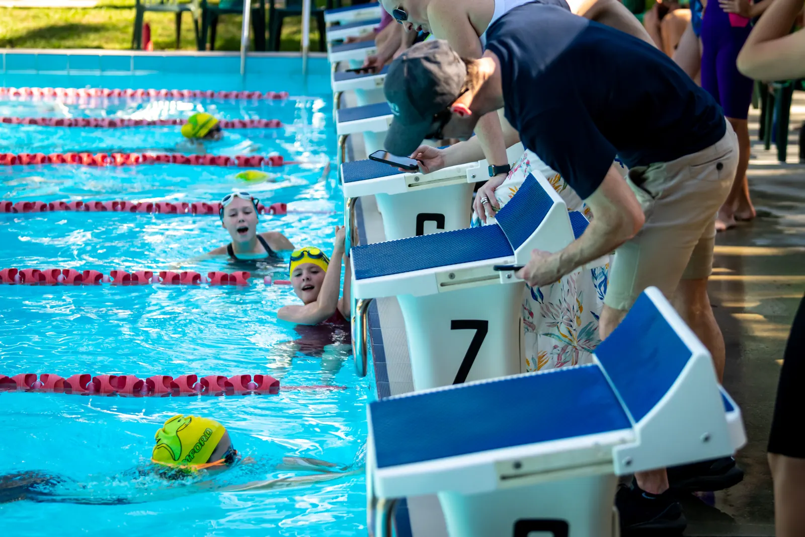 Timekeepers leaning over the lanes during a race